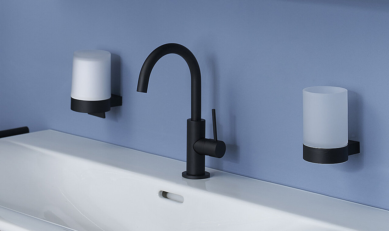 Hölzerner Waschtisch mit weißem Waschbecken, einem schwarzen Wasserhahn, einem verspiegelten Medizinschrank mit einer offenen Tür.