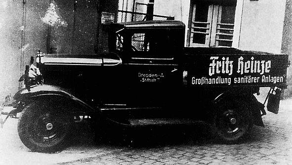 chwarz-Weiß-Foto eines Lastwagens aus den 1930er-Jahren mit der Aufschrift „Fritz Heinze – Großhandlung sanitärer Anlagen“ auf der Fahrzeugseite.