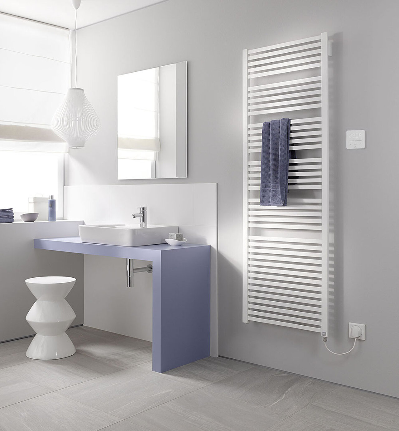 Badezimmer mit blauem Waschtisch, weißem Waschbecken, Wandspiegel und einem weißen beheizten Handtuchhalter.