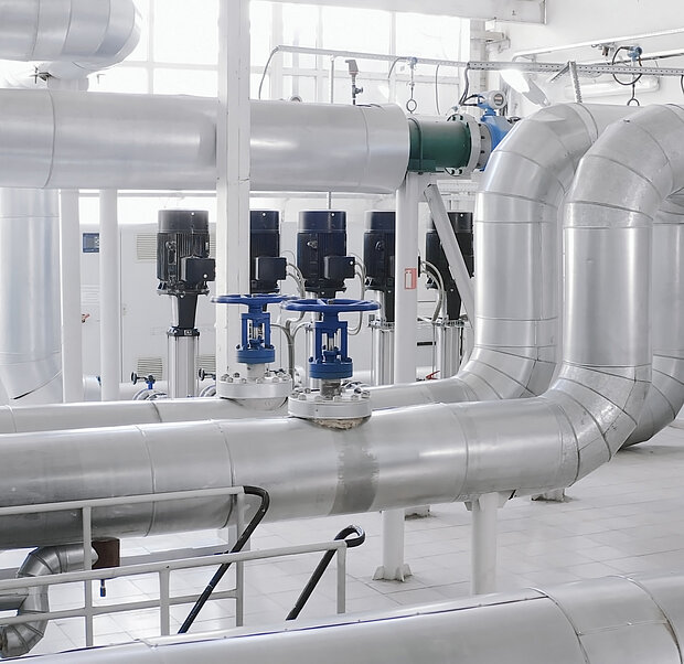 Große Rohre und Ventile in einer hellen, sauberen Anlage.