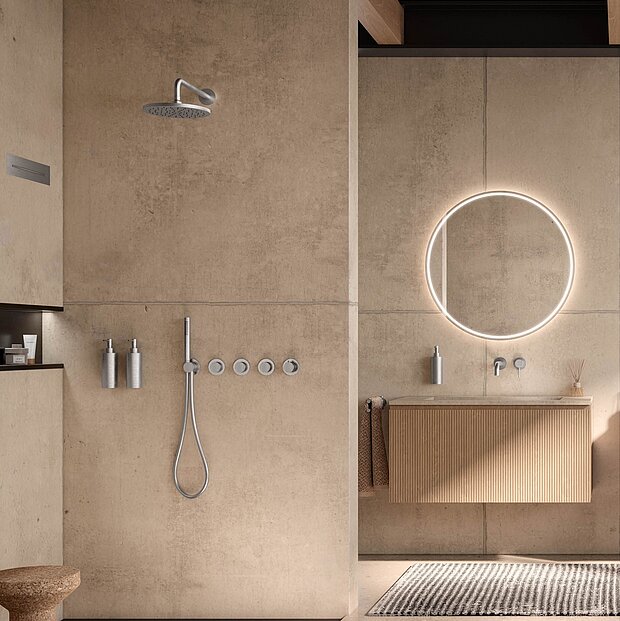 Minimalistisches Bad mit einer begehbaren Dusche mit Regenduschkopf, wandmontierten Armaturen, einem runden, hinterleuchteten Spiegel über einem schwebenden Waschtisch.