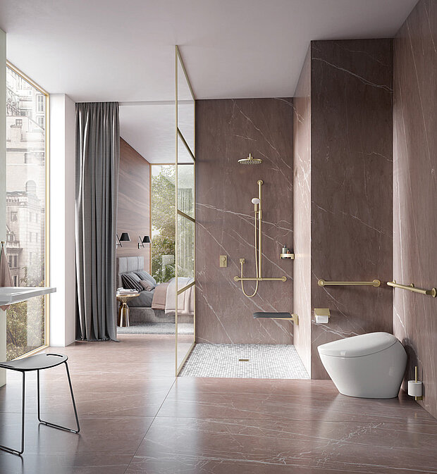 Modernes Badezimmer mit braunen Marmorwänden und -böden, goldenen Armaturen, begehbarer Dusche mit Haltegriffen und Klappsitz sowie einer weißen Toilette. 