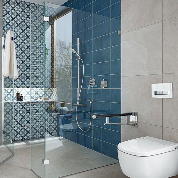 Modernes Badezimmer mit einer Glasduschkabine, blauen und gemusterten Fliesen