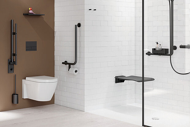 Modernes barrierefreies Bad mit wandhängendem WC, brauner Rückwand und weißen Fliesen, eine bodengleiche Dusche mit klappbarem Sitz, Haltegriffe und Armaturen in mattschwarz.