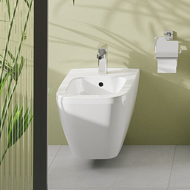 Ein modernes weißes Wandbidet mit einem verchromten Wasserhahn.