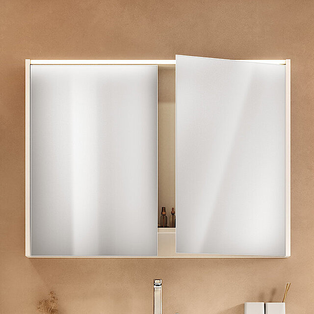 Ein Badezimmerschrank mit zwei großen Spiegeltüren, von denen eine leicht geöffnet ist