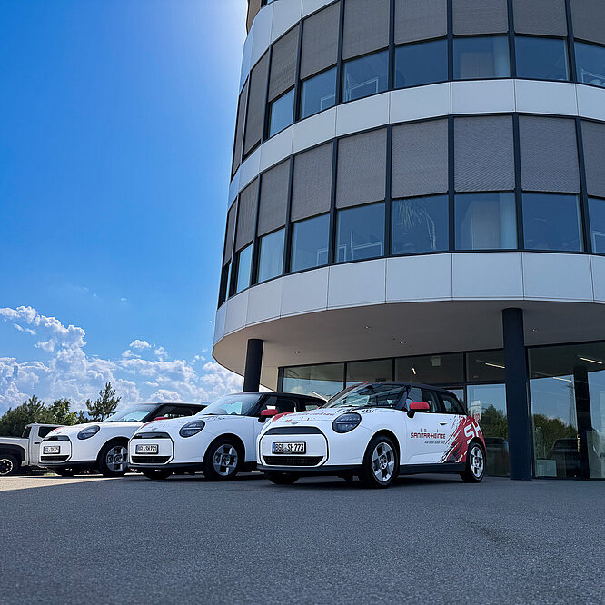 3 neue E-Minis im Sanitär-Heinze-Design stehen vor der Zentrale in Ainring