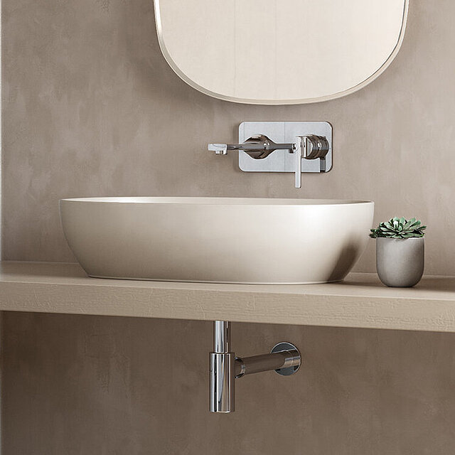 Ein modernes Aufsatz-Waschbecken mit einem schlanken, ovalen Becken und einem an der Wand montierten Wasserhahn.
