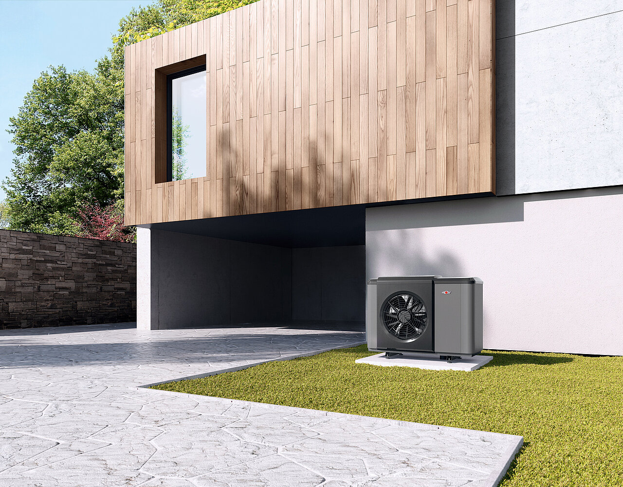 Haus mit moderner Holz-Beton-Fassade und sichtbarer Wärmepumpe im Außenbereich