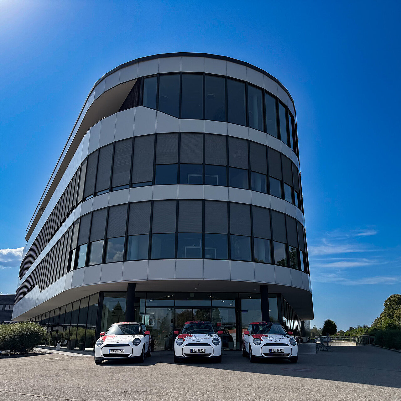 3 E-Minis im Sanitär-Heinze-Design stehen vor der Zentrale in Ainring