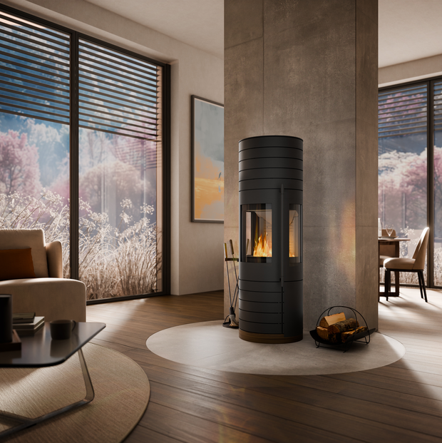 Modernes, helles Wohnzimmer mit großen Fenstern, Holzofen in der Mitte, Brennholzkorb und Sofa.