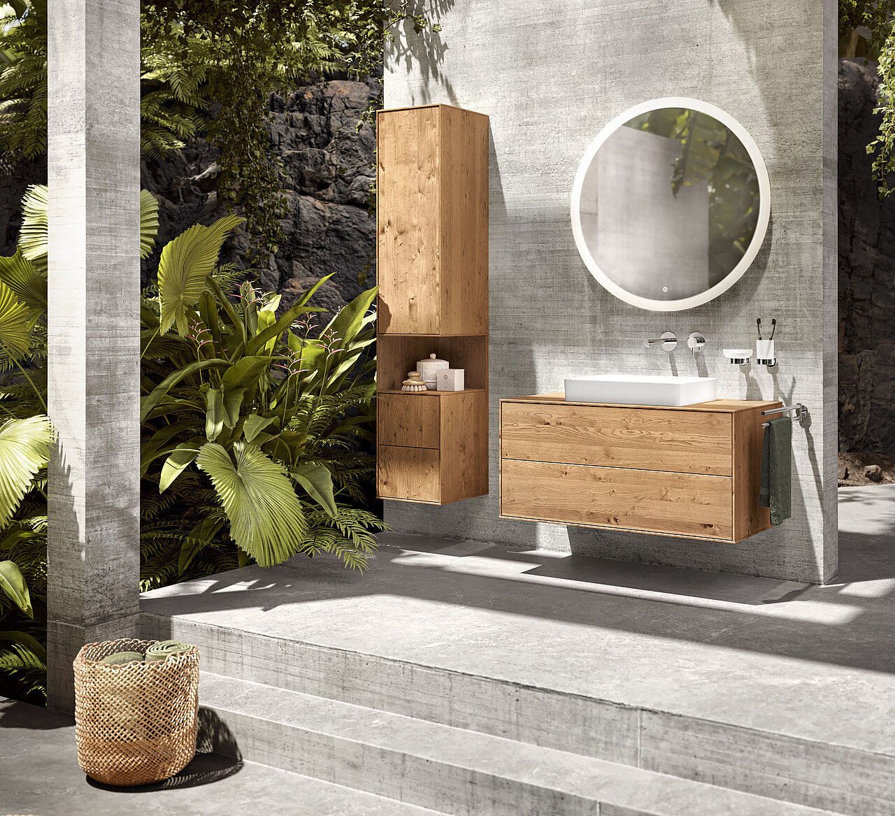 Modernes Badezimmer im Freien mit hellen Holzschränken, einen runden beleuchteten Spiegel, ein weißes Waschbecken und Betonwände und -boden.
