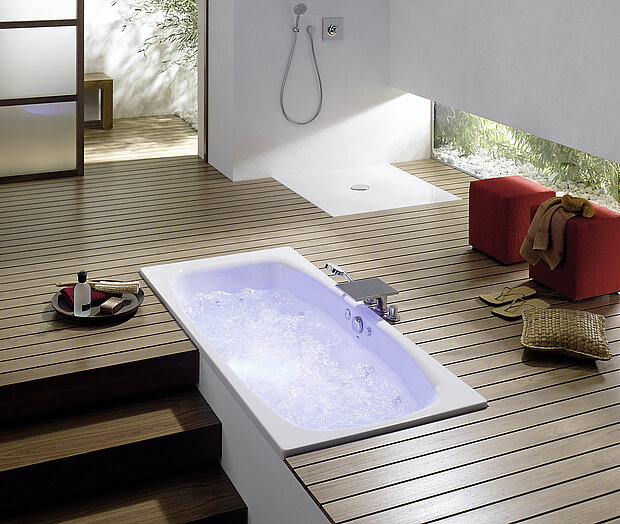 Modernes Badezimmer mit einer eingebauten Badewanne, mit sprudelndem Wasser und einer begehbaren Dusche und Holzboden.